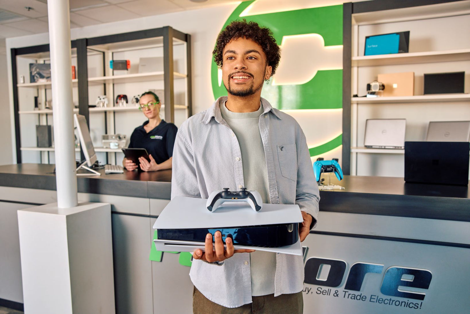 man holding a PlayStation 5 and smiling